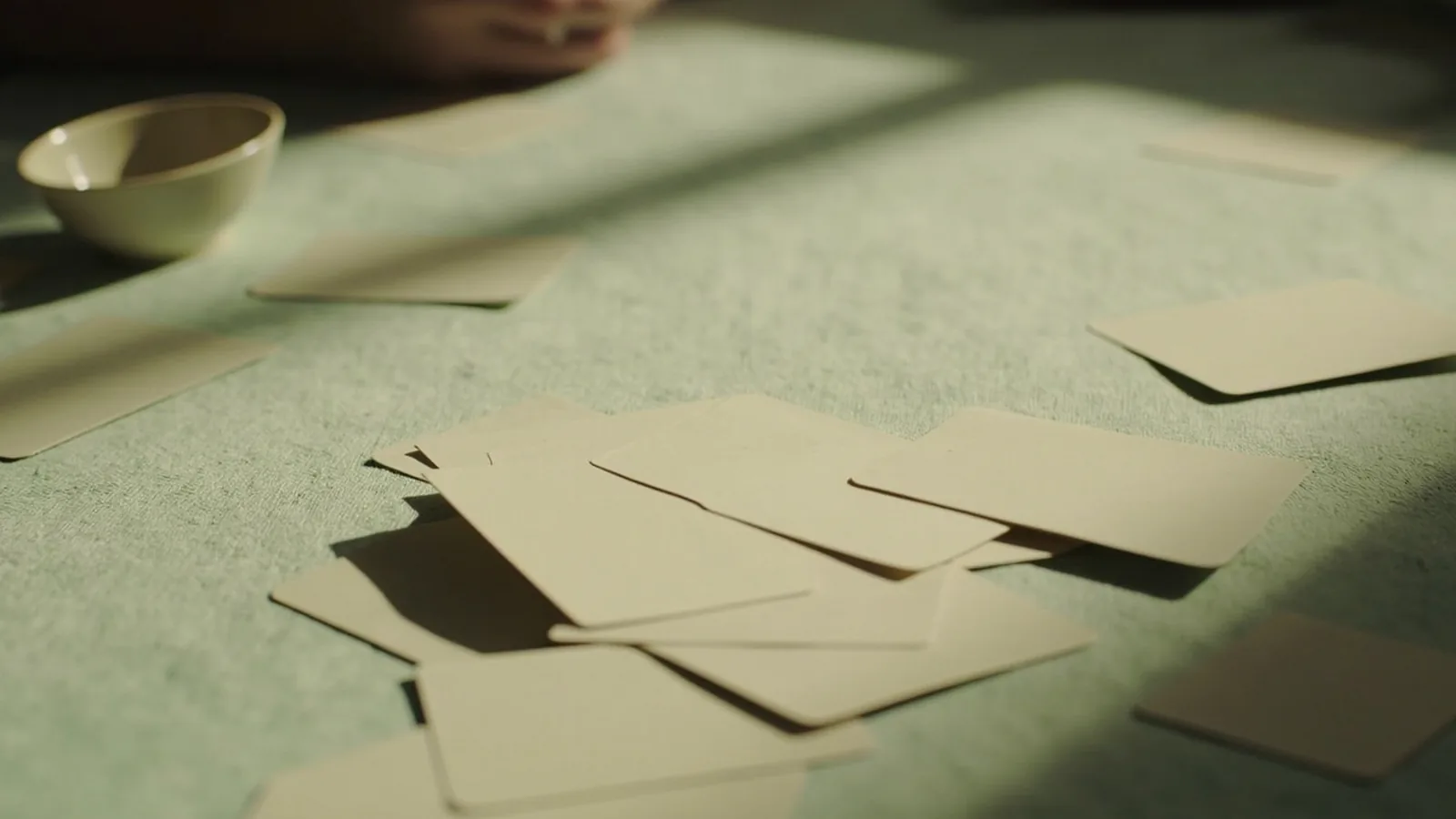Diagonal crop of a short discard pile and face-down packets on mint linen